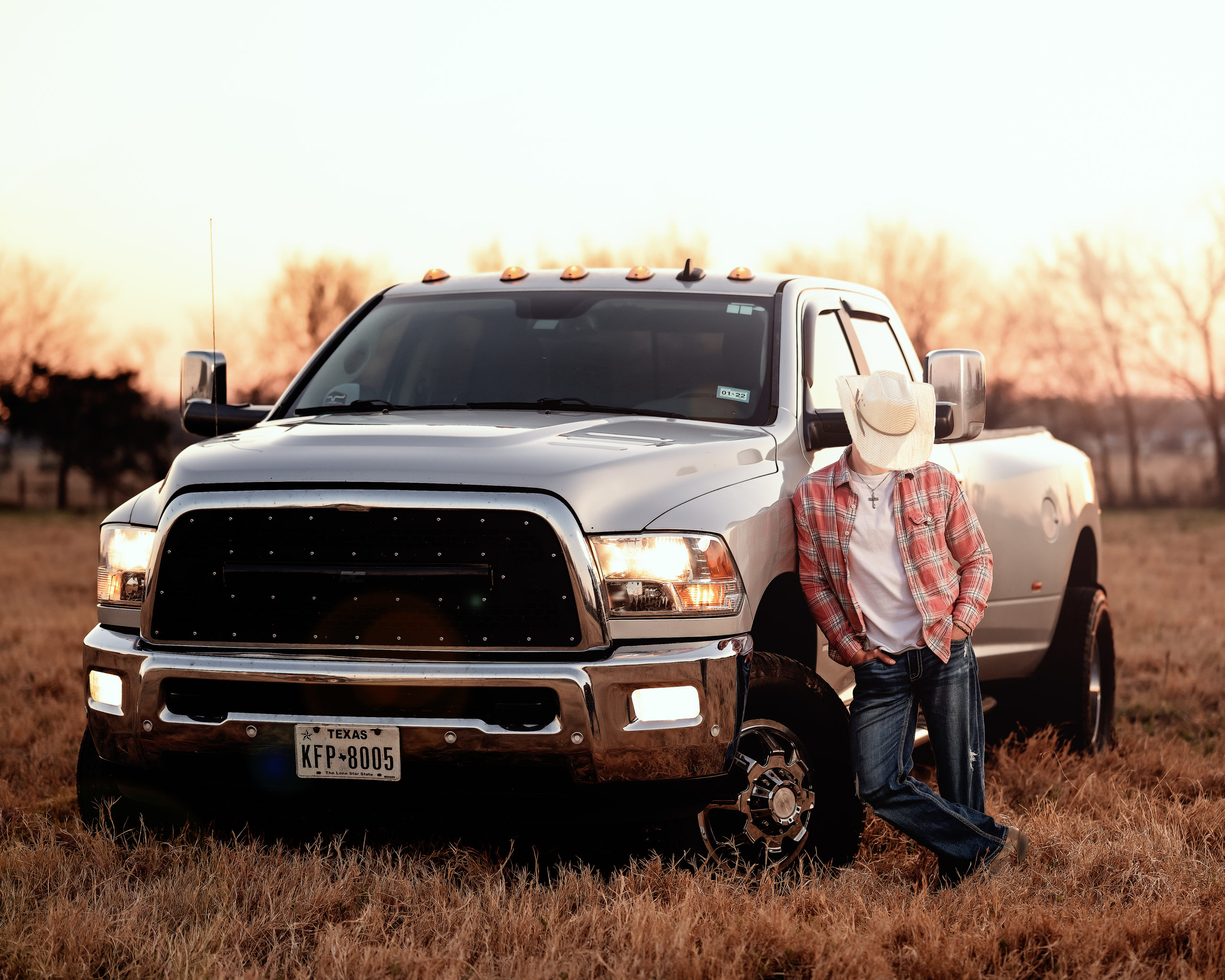 Senior portrait at sunset with his truck and cowboy hat