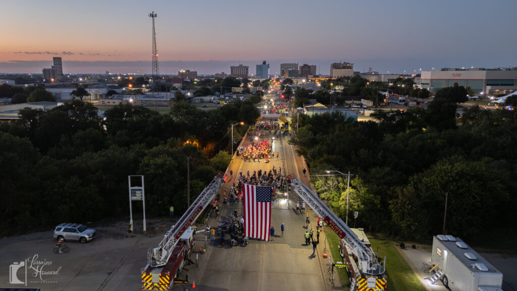 Drone photo of Hotter’N Hell Hundred 2025 start line in downtown Wichita Falls with thousands of cyclists at sunrise.