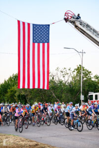 Large group of cyclists riding together at the start of Hotter’N Hell Hundred 2025 in Wichita Falls, Texas